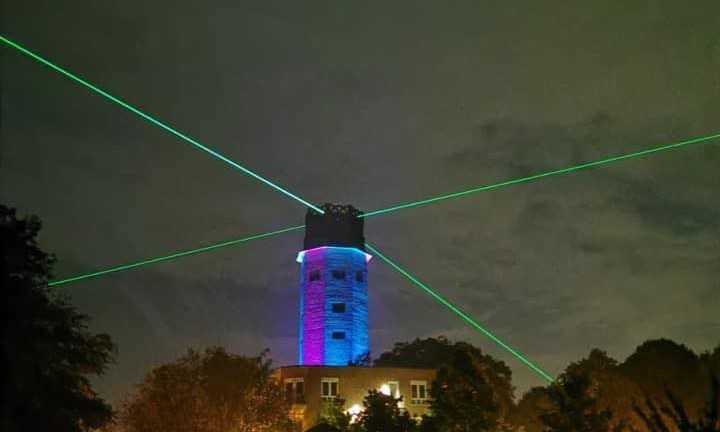 Wasserturm angestrahlt und mit Lasern in alle Himmelsrichtungen