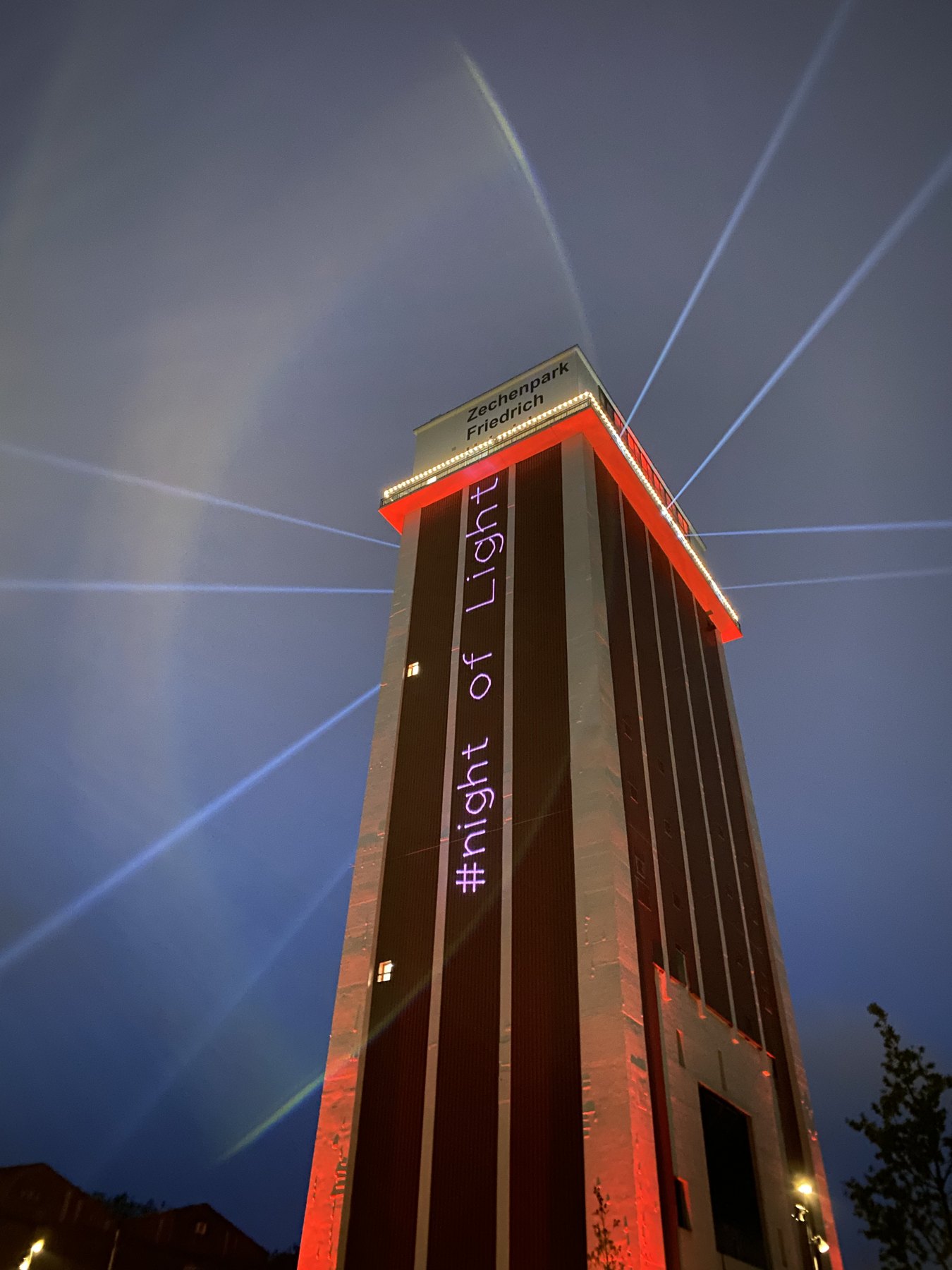 Beleuchteter Turm mit Lichtstrahlen bei Nacht