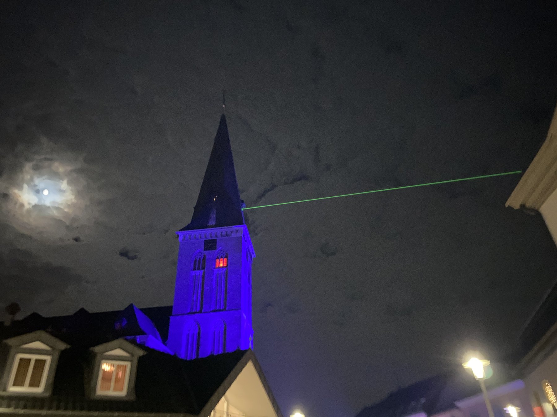 Blau beleuchteter Kirchturm bei Nacht